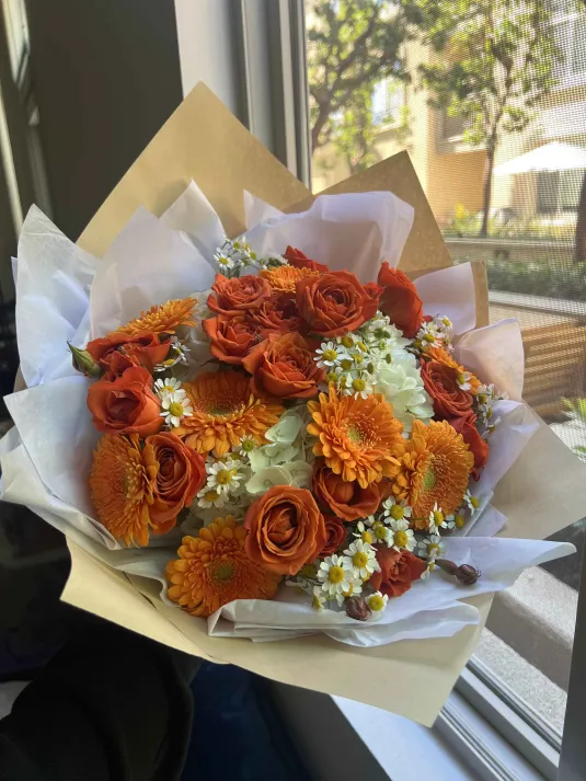 Loose editorial floral arrangement in warm neutral tones.